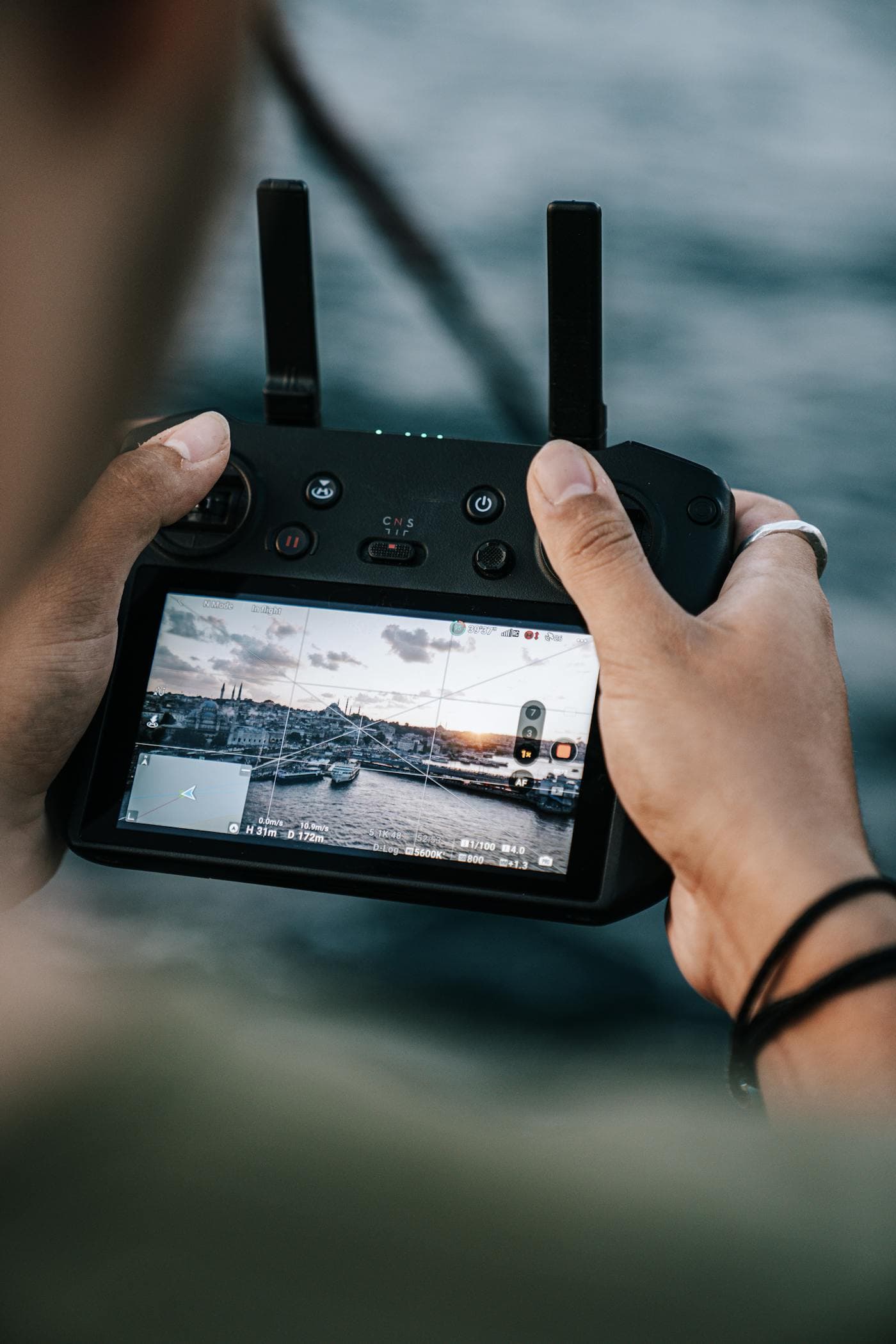 Professional drone controller with built-in screen showing live aerial footage