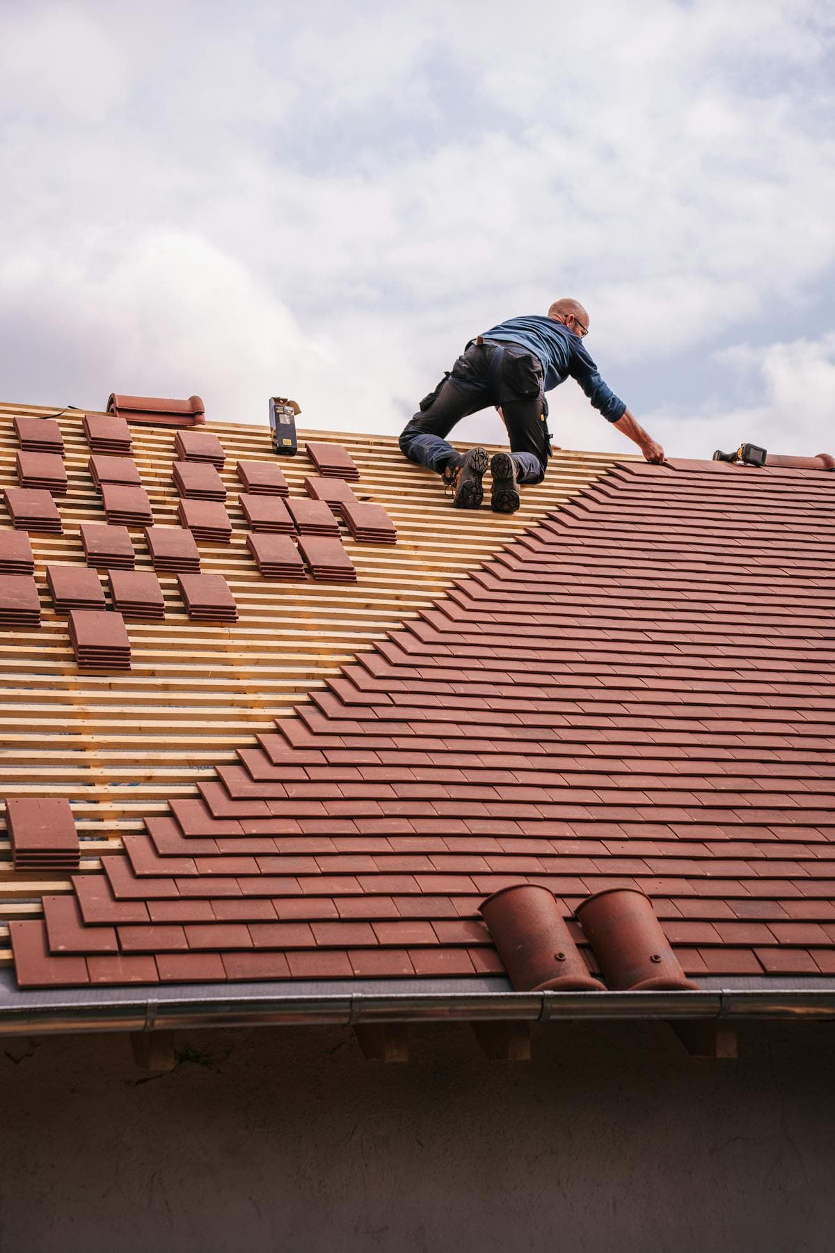Roofer documenting a residential roof during exterior repair work